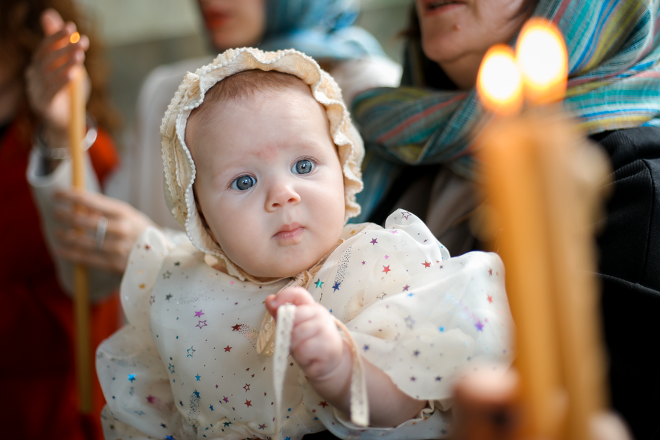 Bébé entouré de sa famille pendant le baptême