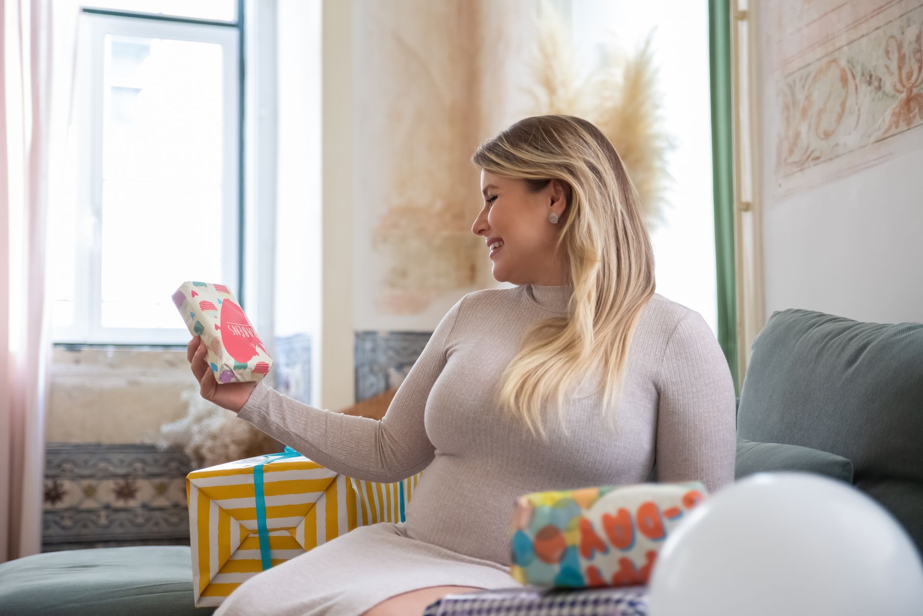 Future maman souriante entourée de cadeaux