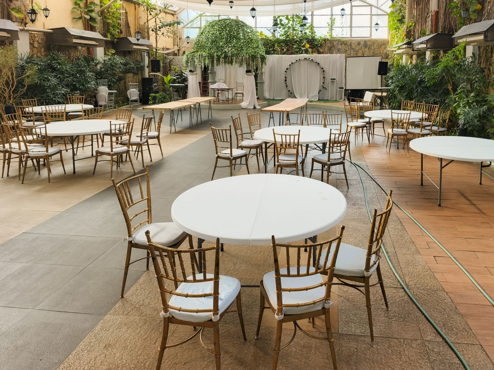 Salle de réception avec tables rondes disposées avant l’arrivée des invités