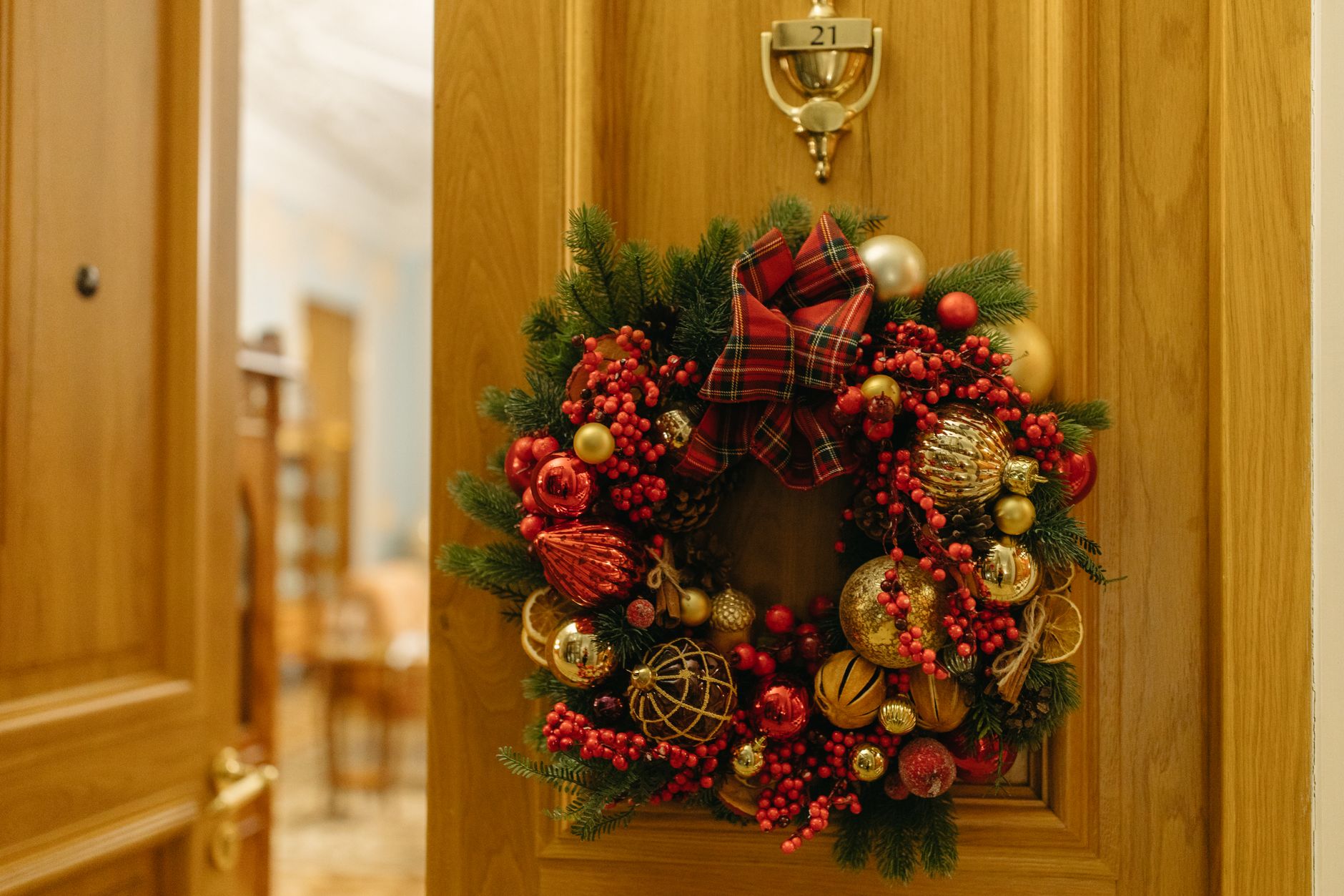 Couronne de Noël avec boules et baies sur une porte en bois