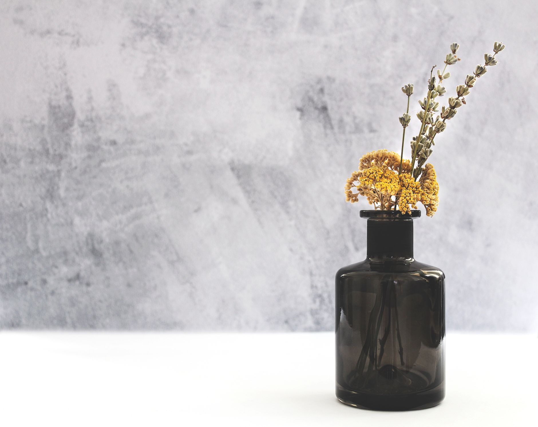 Fleurs séchées dans un vase en verre sombre
