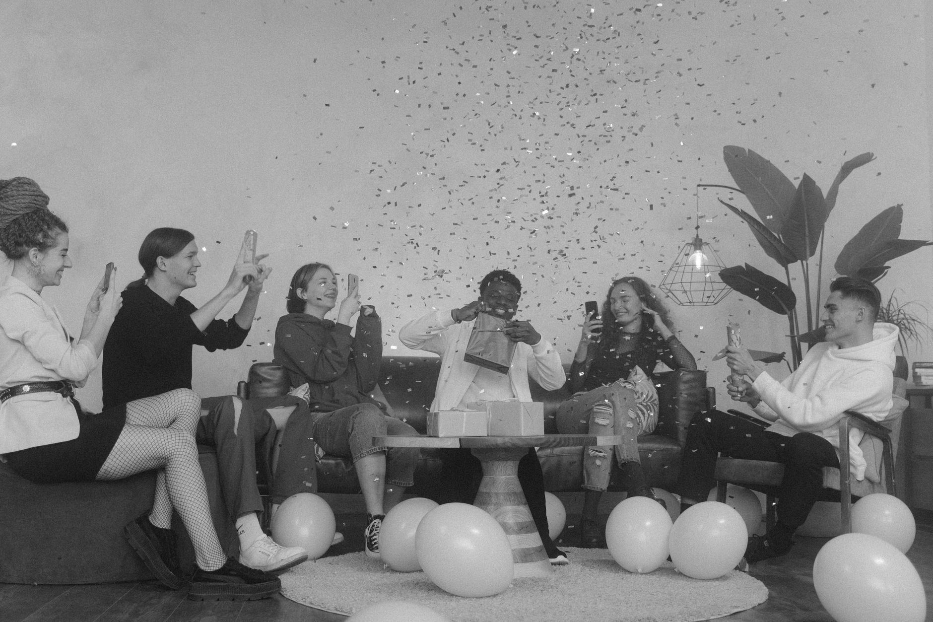 Fête entre amis sous une pluie de confettis en noir et blanc