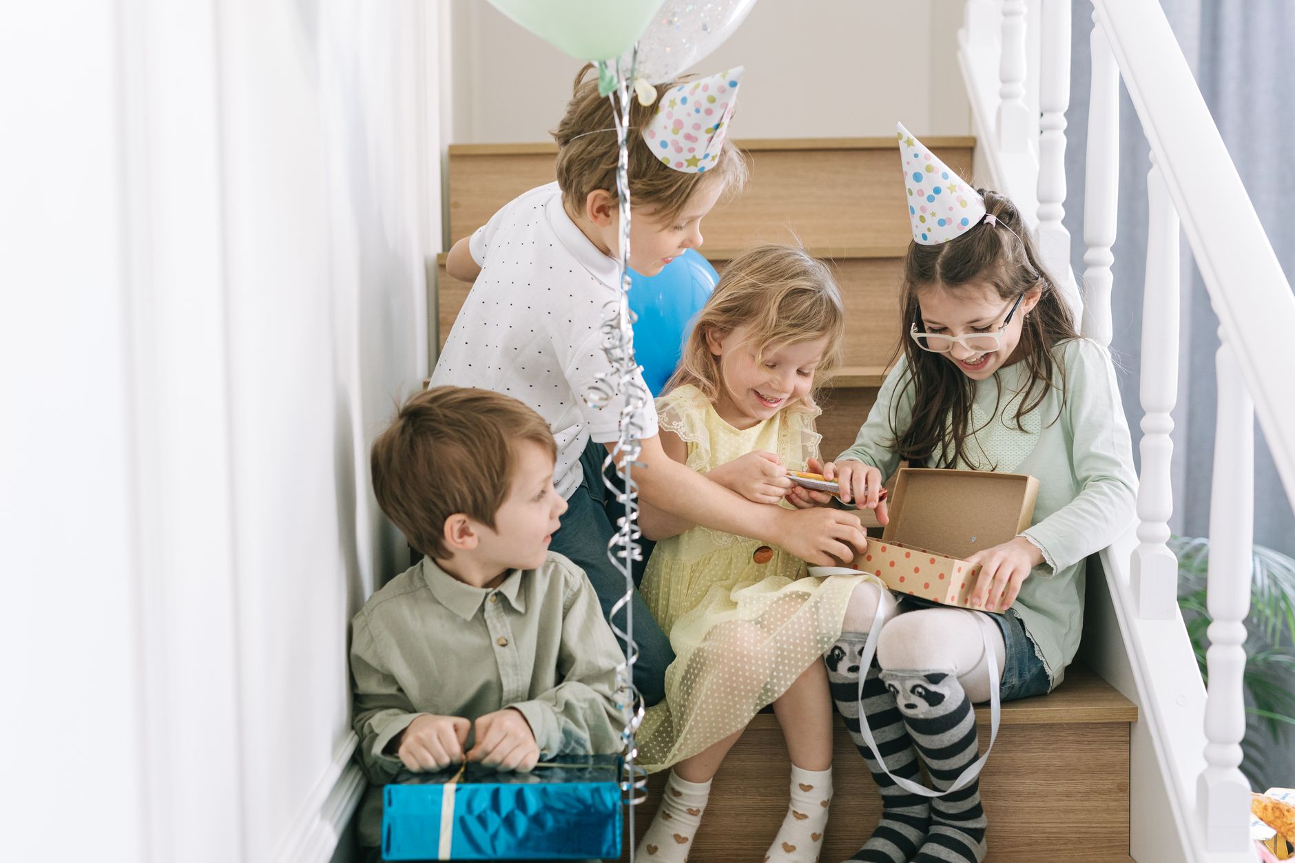Enfants avec cadeaux et ballons dans un escalier