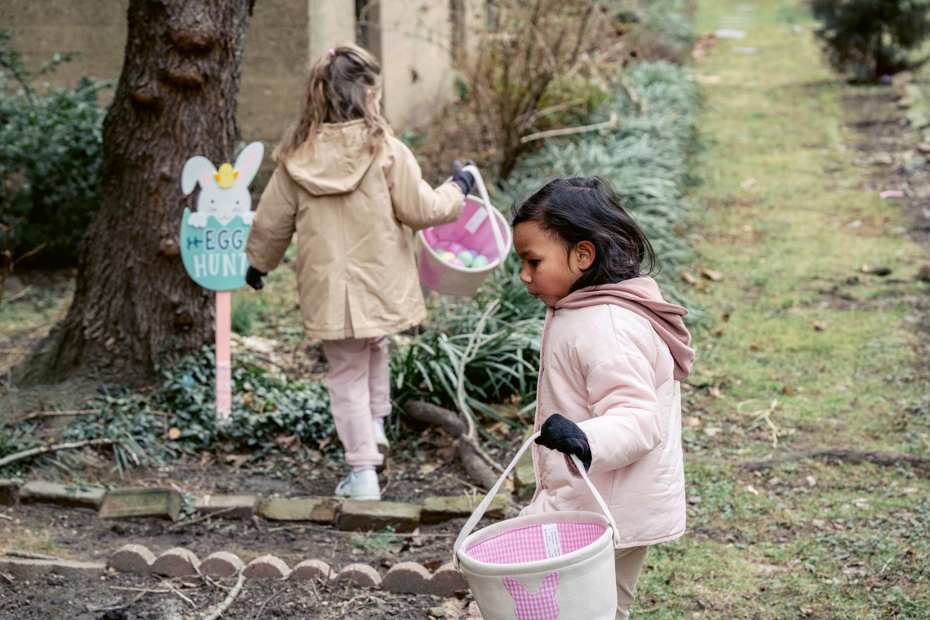 Fillettes ramassant des œufs de Pâques dans un parc