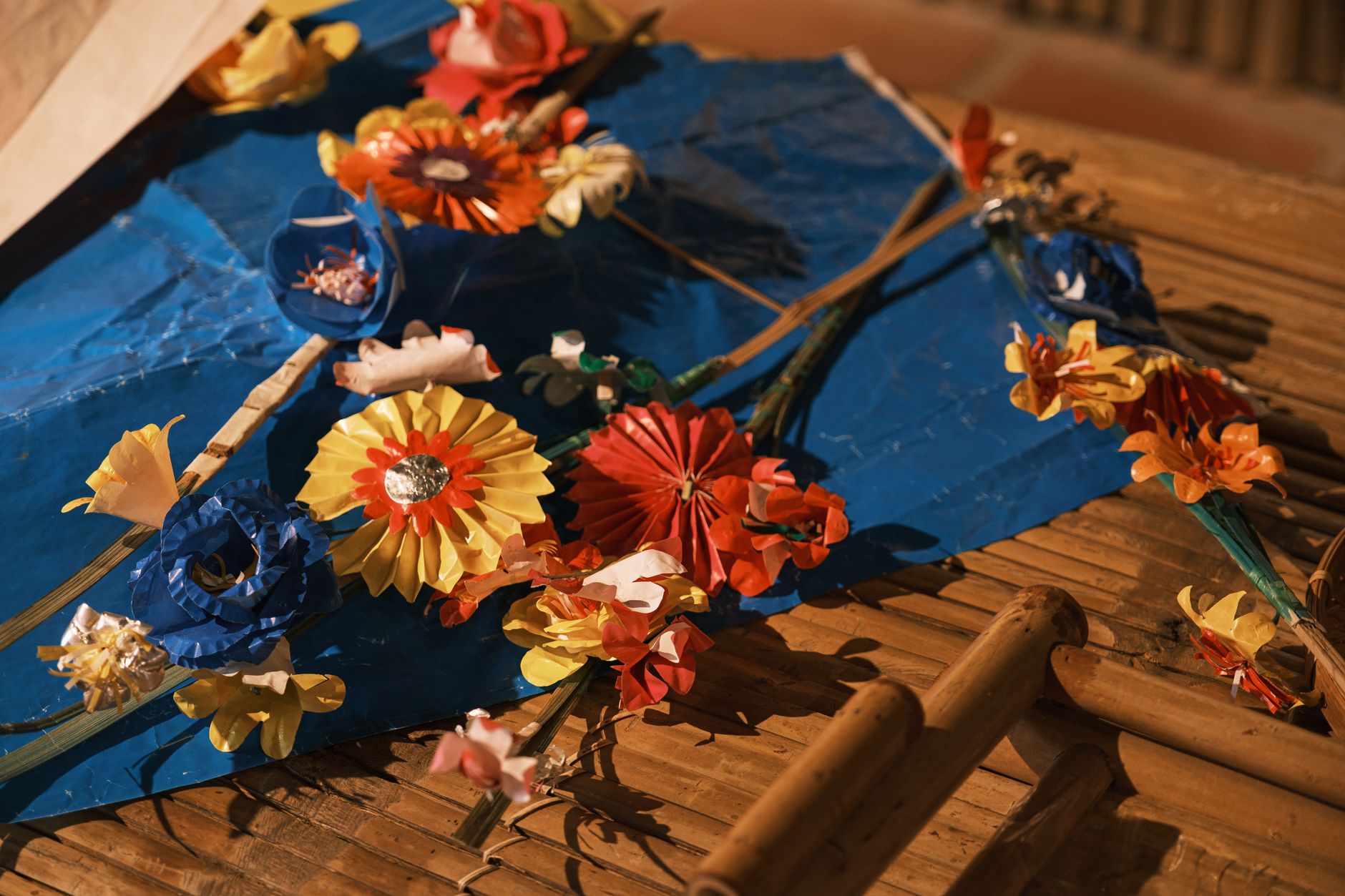 Fleurs en papier faites main posées sur une surface en bambou