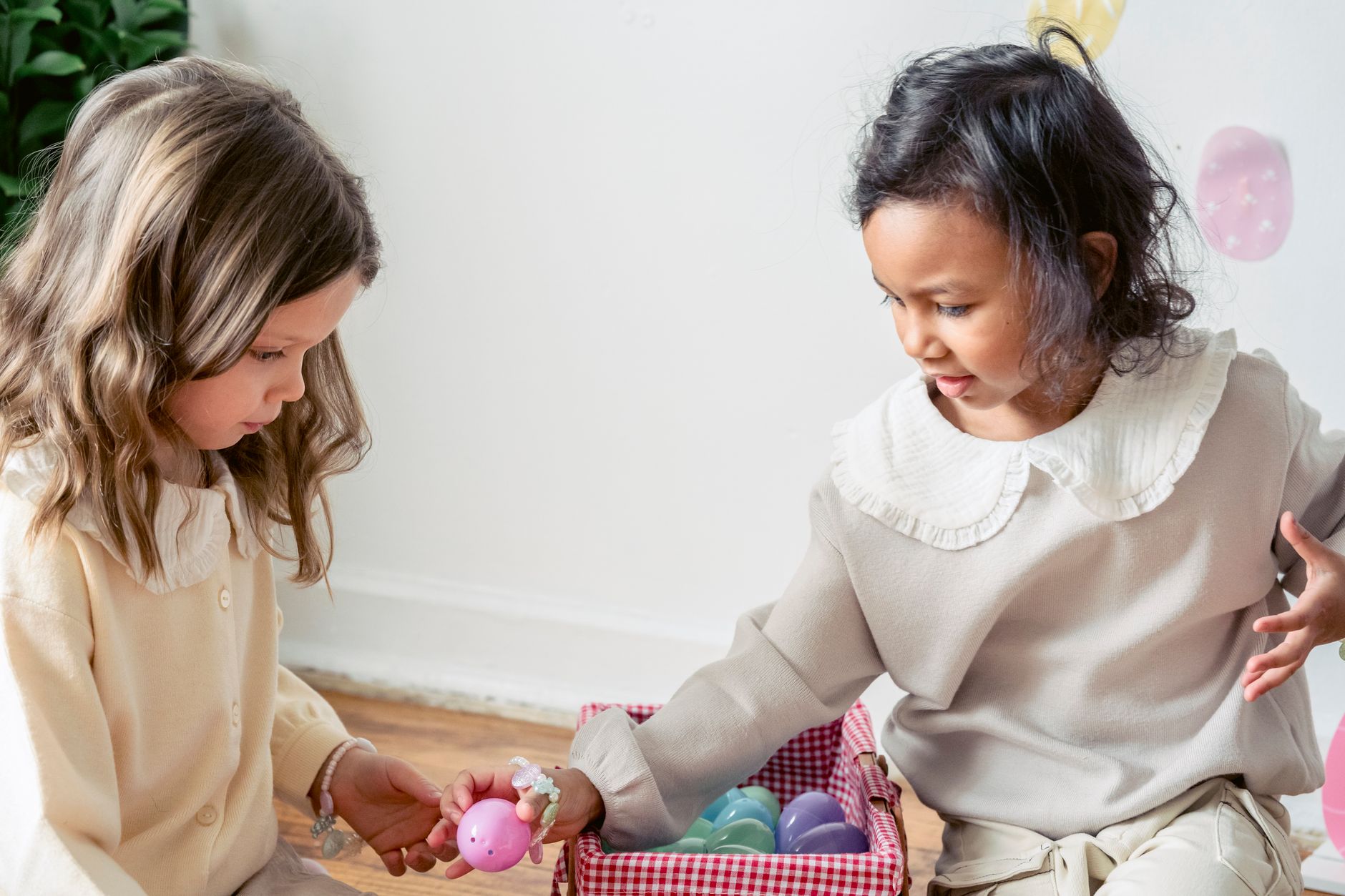 Enfants entourés d’œufs en plastique colorés à la maison