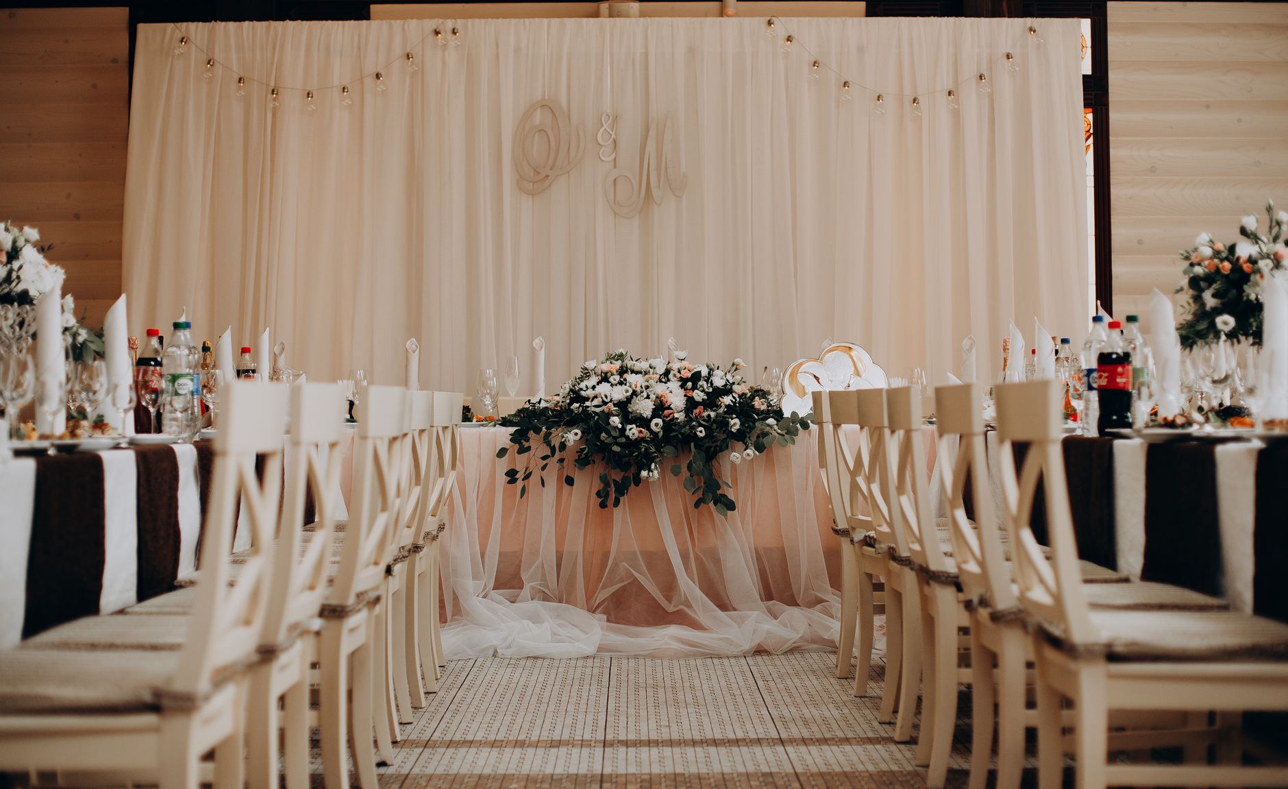 Réception élégante avec fleurs et chaises claires
