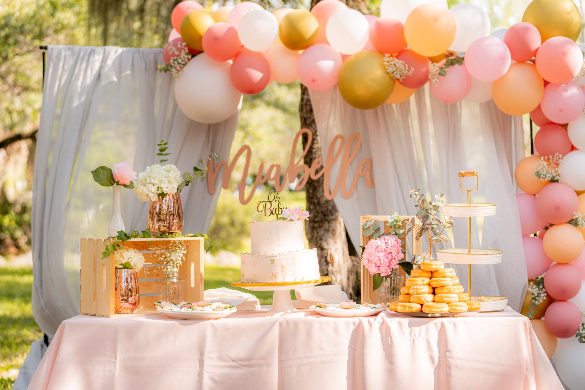 Table de fête avec gâteau et ballons dans un jardin