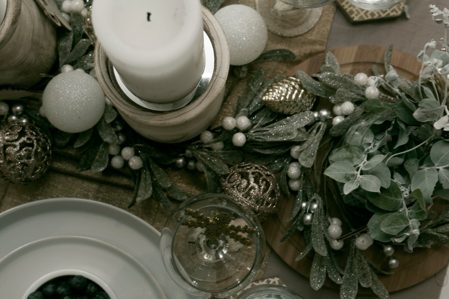 Table de Noël dressée avec bougie et branches de sapin